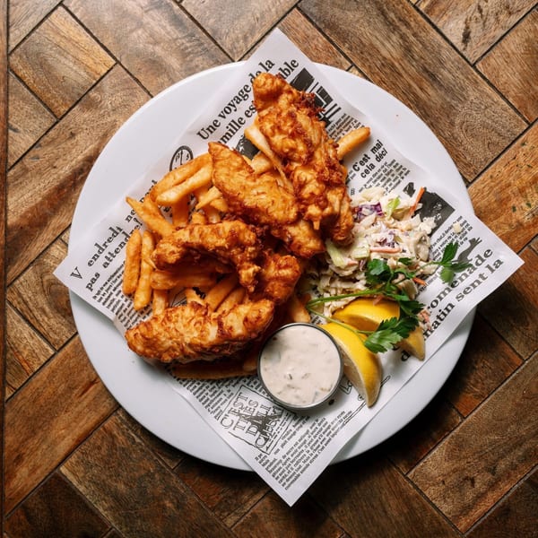 Rosie McCann's Irish Pub's fish and chips with coleslaw, lemon wedges, and tartar sauce.