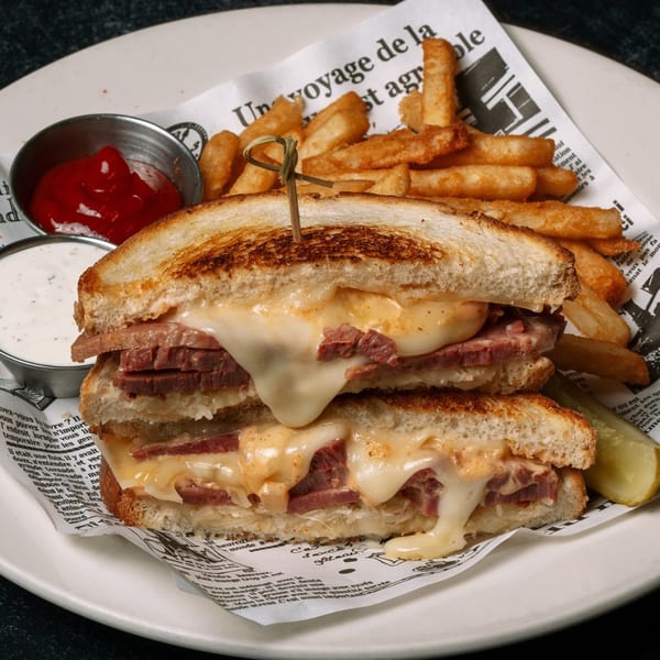 Rosie McCann's Reuben sandwich with melted cheese, corned beef, fries, ketchup, and ranch dressing.