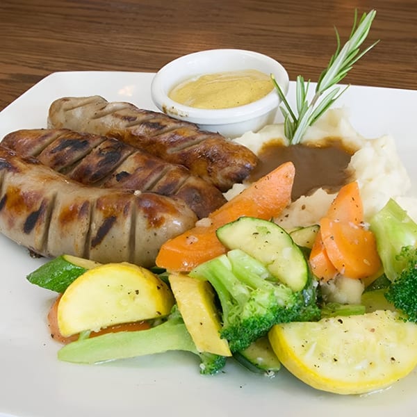 Rosie McCann's Irish Pub & Restaurant's grilled sausages with mashed potatoes, gravy, mustard, and mixed vegetables.